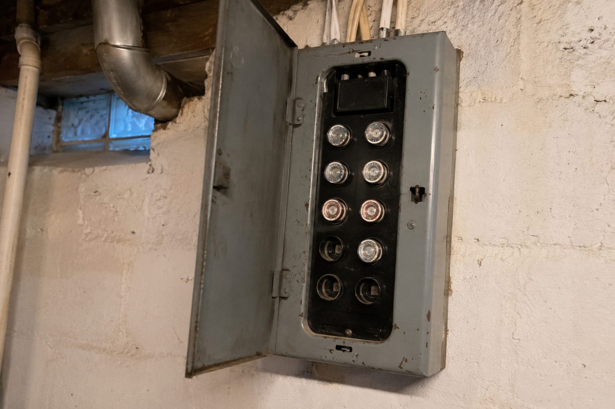An old screw-in fuse box on a basement wall, a sign it may be time for a panel upgrade